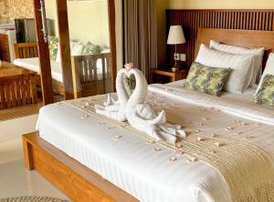 2 cygnes assis sur un lit dans une chambre d'hôtel dans l'établissement Uma Phala Villa, à Ubud
