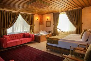 a bedroom with a bed and a red couch at Zeppelin Cappadocia in Uçhisar