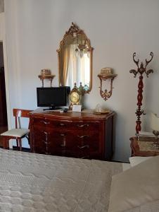 a bedroom with a dresser with a mirror and a bed at B&B Assereto in Rapallo