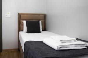 イスタンブールにあるMesil Hotelのベッド(白いシーツ、黒い枕付) +6枚の写真