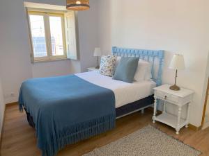 アトウギア・ダ・バレイアにあるCasa da Travessa by Madrabicaのベッドルーム(青と白のベッド1台、窓付)