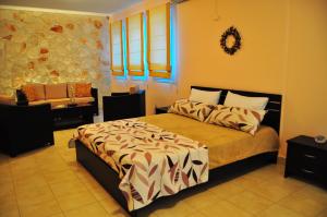 a bedroom with a bed and a couch in it at Pyrgos Zante Suites in Alikanas +23 photos
