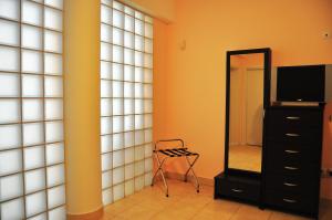 a room with a mirror and a chair and a dresser at Pyrgos Zante Suites in Alikanas