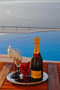 a bottle of wine and a plate of fruit and wine glasses at Pyrgos Zante Suites in Alikanas