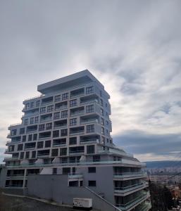 a tall white apartment building with a sky at GLAMOUR Style Apartment in Cluj-Napoca