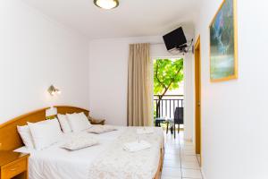 a bedroom with a bed and a balcony at Astali Hotel in Rethymno Town