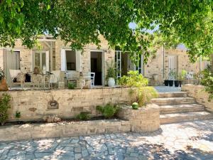 a house with a stone wall and a patio at Villa Sylvia 1 in Matala