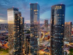 two tall skyscrapers in a city at night at Modern 2 Bed Penthouse with Stunning views in Manchester City Center in Manchester +14 photos