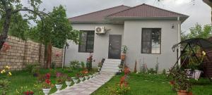 a small white house with flowers in the yard at Samall new villa FRHD in Gabala +4 photos