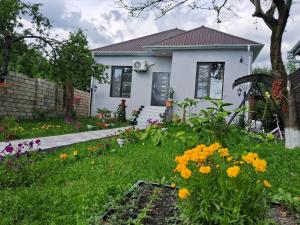 a white house with flowers in the yard at Samall new villa FRHD in Gabala