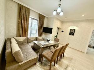 a living room with a couch and a table at Samall new villa FRHD in Gabala