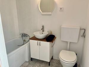 y baño con lavabo, aseo y bañera. en Wildrose holiday home, en Badacsonytomaj
