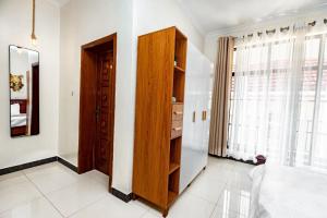 1 dormitorio con armario de madera y ventana en kigali Pillar House inn, en Kigali 52 fotos más