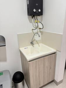 baño con lavabo y dispensador en la pared en Apartasuite 206, en Armenia 6 fotos más