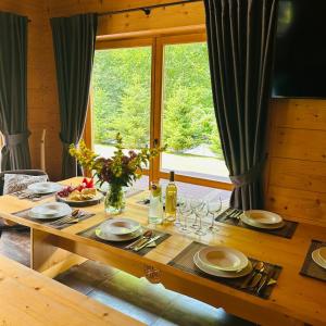 une table en bois avec des assiettes et des verres à vin dessus dans l'établissement Osada nad potokiem, à Kościelisko