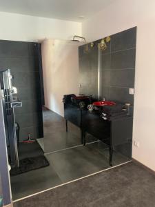 ein Bad mit einem schwarzen Waschtisch und einer Dusche in der Unterkunft dream room in Saint-Amand-Montrond