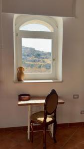 a table with a chair in front of a window at Agorà nei sassi in Matera