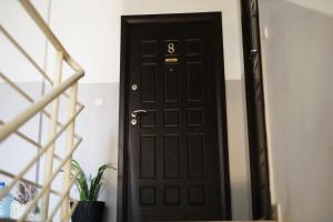 a black door with the number eight on it at ILIEVSKI apartment 8 in Kumanovo