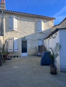 a stone building with a large courtyard in front of it at Maison de ville in Cognac