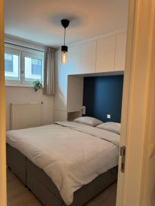 a bedroom with a large bed with white cabinets at Beach Addict Appartment Duinrust in Knokke-Heist