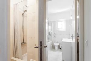 a white bathroom with a shower and a toilet at Casa da Linha in Cascais +26 photos