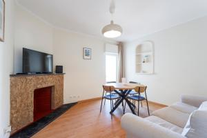 a living room with a table and a fireplace at Casa da Linha in Cascais