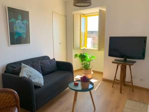 アトウギア・ダ・バレイアにあるCasa da Travessa by Madrabicaの青いソファとテレビのあるリビングルーム