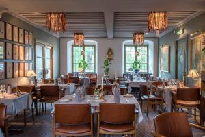 a dining room with tables and chairs and chandeliers at Hotell Lindgården in Visby