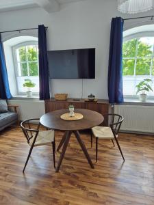 a living room with a table and two chairs at Studio 1 - Apartments am Schloss in Oberschleißheim