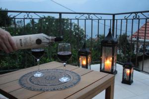 a person pouring wine into two glasses on a table at Sunny Days Villa in Prčanj