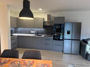 una cucina con frigorifero e tavolo con sedie di Ubytování v Beskydech - Frýdlant nad Ostravicí a Frýdek-Místek Altre 24 foto