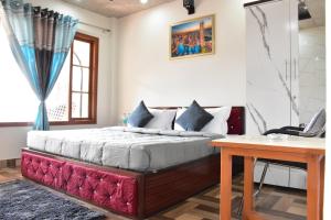 a bedroom with a bed and a desk and a computer at The Couples Paradise Balcony in Kasauli