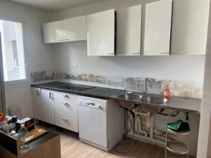 a kitchen with white cabinets and a sink at Spacious T3 appart nearby la defense & Arena in Puteaux