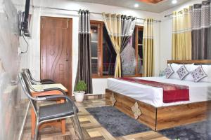 a bedroom with a bed and a chair and a window at The Couples Paradise Balcony in Kasauli