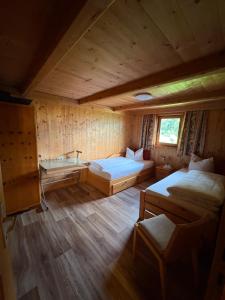 a room with two beds and a desk in a cabin at Talgenbichl in Bruck am Ziller