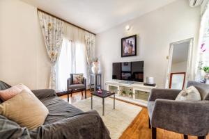 sala de estar con sofá y TV en Holiday Home & Apartments Primavera, en Pula