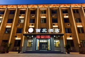 Un edificio con un cartel en el frente. en 金江西北大酒店, en Dunhuang