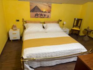ein Schlafzimmer mit einem großen Bett in einem gelben Zimmer in der Unterkunft A Casa di Cheope in Bettolelle