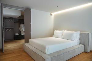 a bedroom with a white bed and a closet at Angela Suite - Luxury loft near Politecnico and city center in Turin