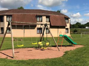 a playground in front of a house at Logis Hôtel Delfotel in Hautefond