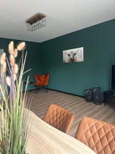 HemmingstedtにあるFerienwohnung Verdeのテーブルと椅子が備わる壁の客室です。