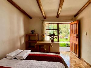 a bedroom with a bed and a door with a window at La Huerta Refugio in Urubamba