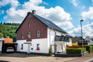 a large white house with a brown roof at Rennglück Apartments in Kelberg