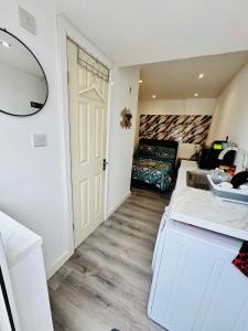 a room with a sink and a room with a couch at Enjoy the comfort at self-contained studio with free Parking - near Luton airport in Luton