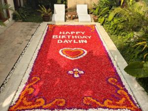 un tapis rouge avec les mots joyeux anniversaire daisin dessus dans l'établissement Uma Phala Villa, à Ubud