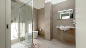 a bathroom with a shower and a sink and a toilet at RRRapido Corte del Naviglio - Apartments in Corsico