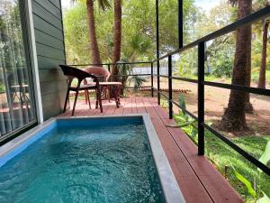 a pool on a porch with a table and a chair at Leopard Inn Wilpattu in Ilavankulam