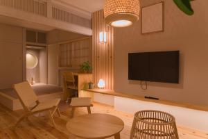 a living room with a flat screen tv on a wall at Forest Japandi House in Osaka