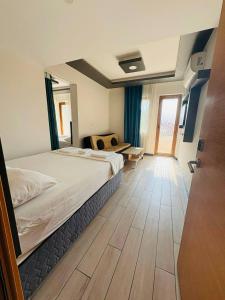 a bedroom with a large bed and a wooden floor at Sarıgerme Apart otel in Ortaca