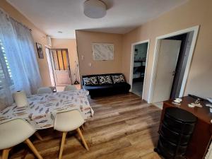 a living room with a table and chairs and a couch at Apartman Juran in Murter